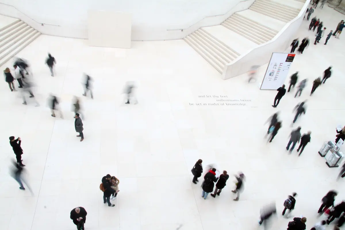 A spacious white-walled hall with people walking